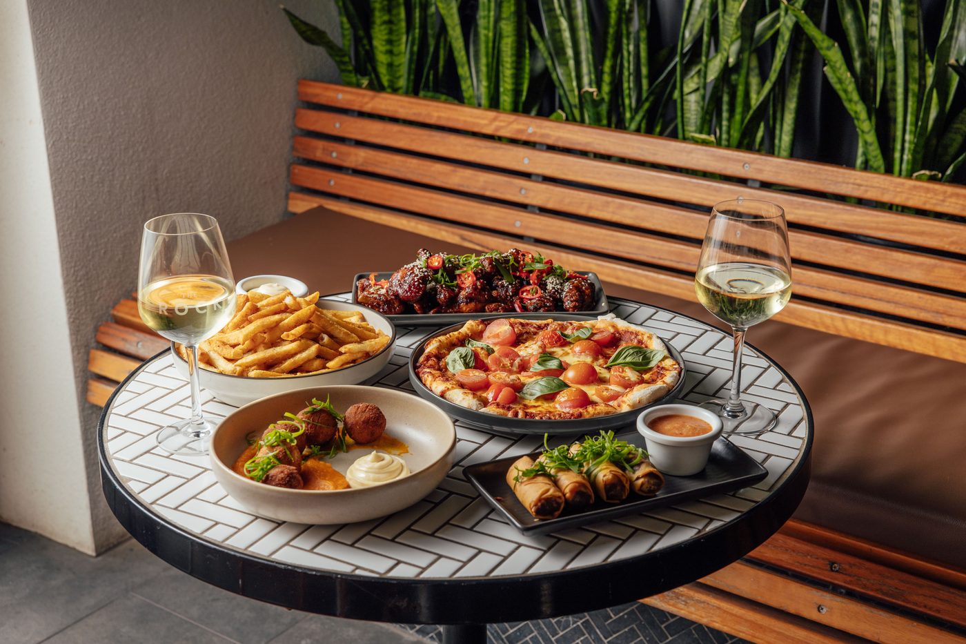 Pizza, wings, chips and arancini shared at a table at The Rock Toowoomba